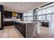 Bright kitchen with dark cabinets, gold hardware, large island with white marble countertop, and floor-to-ceiling windows at 395 Breakwater Dr, Fishers, IN 46037
