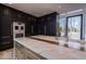 Modern kitchen with large island, stainless steel oven, and dark cabinets with gold hardware at 395 Breakwater Dr, Fishers, IN 46037