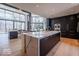 Spacious kitchen with dark cabinets, gold hardware, large island with white marble countertop, and floor-to-ceiling windows at 395 Breakwater Dr, Fishers, IN 46037