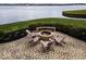 Charming patio with a cozy fire pit, surrounded by lush landscaping and scenic waterfront views at 395 Breakwater Dr, Fishers, IN 46037