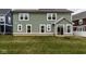 Back of home with a green exterior, windows, and grass yard at 401 Thomas Point Dr, Fortville, IN 46040