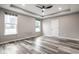 Neutral bedroom offers luxury vinyl plank flooring, two windows, and a ceiling fan at 401 Thomas Point Dr, Fortville, IN 46040