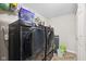 Modern laundry room features sleek black washer and dryer, wire shelving for storage, and neutral-toned tile floors at 4213 Katie Ln, Indianapolis, IN 46239