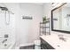 This bathroom features a shower-tub combo, a stylish vanity with a framed mirror, and a modern design at 4255 Kettering Dr, Zionsville, IN 46077