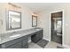 This bright bathroom boasts double sinks with granite countertops and gray cabinets, offering both style and functionality at 4255 Kettering Dr, Zionsville, IN 46077