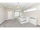 Bright bedroom with a tray ceiling, chandelier, and carpeted floor is enhanced by natural light from three large windows at 4255 Kettering Dr, Zionsville, IN 46077