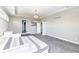 This bedroom features a tray ceiling, a chandelier, carpeted floor, and doors leading to other rooms, creating a cozy retreat at 4255 Kettering Dr, Zionsville, IN 46077