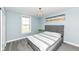 Cozy bedroom with a tufted headboard bed, carpet flooring, and bright window at 4255 Kettering Dr, Zionsville, IN 46077