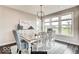 Bright dining room with a large windows, light gray walls, hardwood floors, and a stylish chandelier at 4255 Kettering Dr, Zionsville, IN 46077