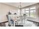 Bright dining room with a large windows, light gray walls, hardwood floors, and a stylish chandelier at 4255 Kettering Dr, Zionsville, IN 46077