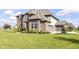 Elegant brick home featuring an attached two-car garage, lush green lawn and beautiful landscaping at 4255 Kettering Dr, Zionsville, IN 46077