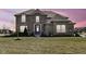 Inviting two-story home with a well-maintained lawn and traditional brick facade at dusk at 4255 Kettering Dr, Zionsville, IN 46077