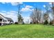 Beautifully landscaped backyard with a large grassy area, mature trees, and charming outbuildings at 450 W Ash St, Zionsville, IN 46077