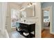 Bright bathroom with a black vanity, dual sinks, patterned tile flooring, and wainscoting at 450 W Ash St, Zionsville, IN 46077