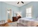 Bedroom with hardwood floors, large window, light blue walls, and decorative dresser at 450 W Ash St, Zionsville, IN 46077