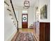 Inviting entryway featuring hardwood floors, staircase, paneled wood door and decorative light fixture at 450 W Ash St, Zionsville, IN 46077