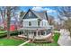 Charming two-story home with a large porch, beautiful landscaping, and lush green grass at 450 W Ash St, Zionsville, IN 46077