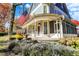 Inviting front porch with decorative trim, an American flag, seasonal decor and lush landscaping at 450 W Ash St, Zionsville, IN 46077