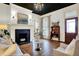 Cozy living room with a black-tiled fireplace, chandelier, and beautiful hardwood floors at 450 W Ash St, Zionsville, IN 46077