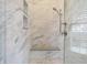 Modern shower with marble tile, a built-in bench, and glass enclosure at 450 W Ash St, Zionsville, IN 46077