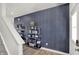 Stylish entryway featuring a mirrored shelving unit with decorative wallpaper, hardwood flooring, and staircase at 4571 Laughter Ln, Indianapolis, IN 46235
