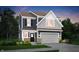 Charming two-story home with a mix of gray and blue siding, a two-car garage, and manicured landscaping at 4571 Laughter Ln, Indianapolis, IN 46235