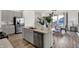 Well-lit kitchen with a gray island, stainless steel appliances, luxury vinyl flooring, and eat-in dining at 4571 Laughter Ln, Indianapolis, IN 46235