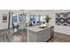 Modern kitchen island with light gray cabinets, a stainless steel dishwasher, and an open floor plan at 4571 Laughter Ln, Indianapolis, IN 46235