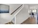 Modern staircase with a wooden handrail, white risers, and luxury vinyl plank flooring at 4571 Laughter Ln, Indianapolis, IN 46235