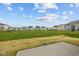 Expansive backyard featuring a well-manicured lawn and a view of neighboring homes under a blue, cloudy sky at 5138 Modernist Blvd, Indianapolis, IN 46237