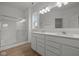Bright bathroom featuring a glass-enclosed shower, double vanity with modern fixtures, and wood-look flooring at 5138 Modernist Blvd, Indianapolis, IN 46237