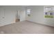 Bright, carpeted bedroom with two windows and an open doorway to the bathroom at 5138 Modernist Blvd, Indianapolis, IN 46237