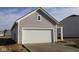 Attached two-car garage with a concrete driveway and light gray vinyl siding at 5138 Modernist Blvd, Indianapolis, IN 46237