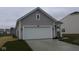 Front of home, featuring a large two-car garage, attractive gray siding, and fresh landscaping at 5138 Modernist Blvd, Indianapolis, IN 46237