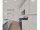 Bright kitchen features white cabinets, stainless steel appliances, quartz countertops, and wood-look flooring at 5138 Modernist Blvd, Indianapolis, IN 46237