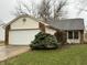 Home exterior showcasing well-maintained lawn and attached two-car garage at 5730 Pemberly Dr, Indianapolis, IN 46221