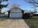 Attached one-car garage featuring a white door and brick accents at 5730 Pemberly Dr, Indianapolis, IN 46221