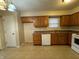Kitchen featuring wood cabinets, white appliances, and tile flooring at 5730 Pemberly Dr, Indianapolis, IN 46221