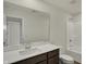 Bathroom featuring a large mirror, vanity sink, toilet, and shower-tub combo at 5777 Greenbrier Ct, Brownsburg, IN 46112