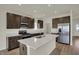 Modern kitchen with an island, stainless steel appliances, dark wood cabinets and recessed lighting at 5777 Greenbrier Ct, Brownsburg, IN 46112