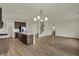 Modern kitchen with a large island, stainless steel appliances, stylish lighting, and wood-look flooring at 5777 Greenbrier Ct, Brownsburg, IN 46112