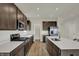 Spacious kitchen with an island, stainless appliances, dark cabinets, light countertops, and tile backsplash at 5777 Greenbrier Ct, Brownsburg, IN 46112