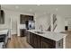 Spacious kitchen island with stainless steel appliances, dark cabinetry, white backsplash and open layout at 5777 Greenbrier Ct, Brownsburg, IN 46112