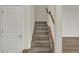 Carpeted stairs with white railing and view into the next room at 5777 Greenbrier Ct, Brownsburg, IN 46112