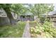 Backyard featuring mature trees, a garden area, grass and a walkway to the back door at 615 E Morris St, Indianapolis, IN 46203