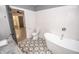 Bright bathroom has tiled floors, toilet, tub and entrance to a closet at 615 E Morris St, Indianapolis, IN 46203