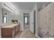 Bright bathroom with a long vanity, decorative plants, and an open doorway to the Primary bedroom at 6180 N Rosewood Dr, McCordsville, IN 46055