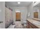 Well-lit bathroom featuring a patterned shower curtain, neutral walls, and marble-look tile flooring at 6180 N Rosewood Dr, McCordsville, IN 46055