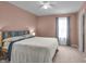 Cozy bedroom with light pink walls, plush carpet, and a large window with sheer curtains at 6180 N Rosewood Dr, McCordsville, IN 46055