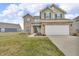 Inviting two-story home featuring a two-car garage, green siding and brick accents at 6180 N Rosewood Dr, McCordsville, IN 46055
